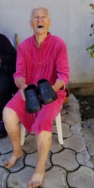 An older friend in Romania is delighted to receive new shoes